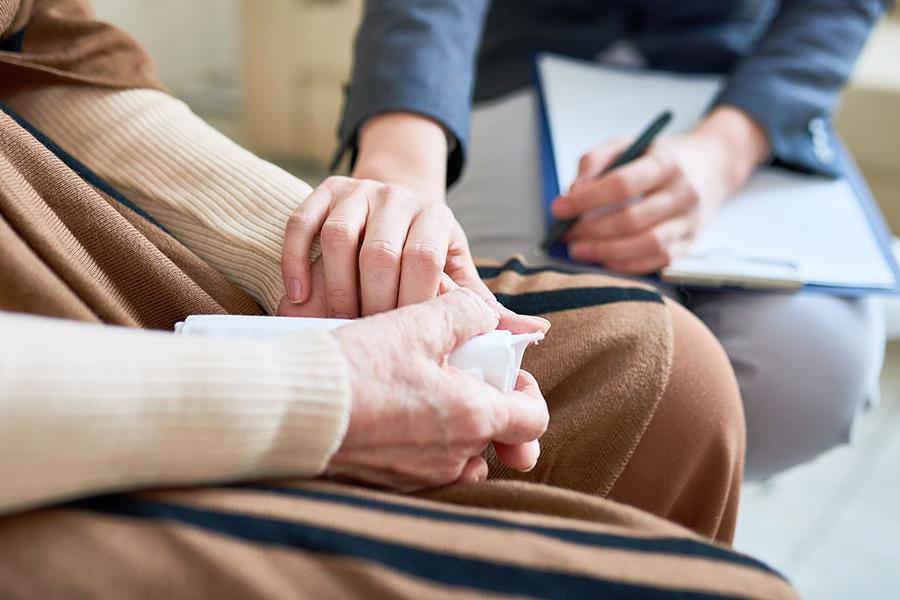 A counselor supporting a patient by holding their h和s